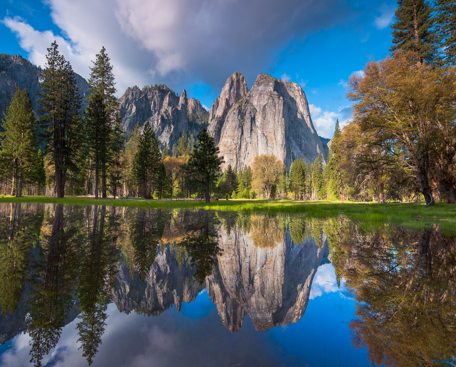 Spring melt creates reflections of the Cathedral Range with clouds stirring around the peaks. A wonderful day in Yosemite.