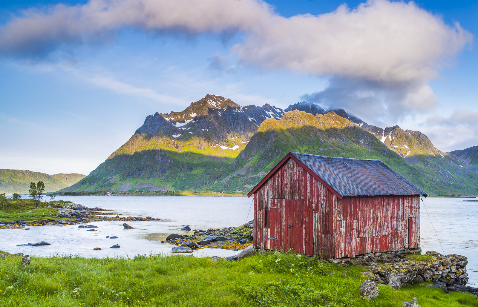 Within one of the endless inlets of Norway a little red shed withstands the weather on its perch.
