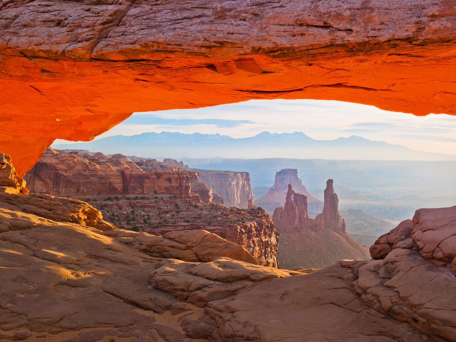 First light shines onto the arche's under belly creating an orange glow at Canyonlands NP.