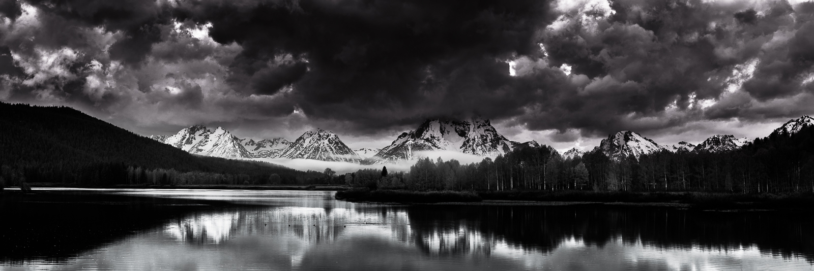 A new day is born at Oxbow Bend and the clouds tower above the mountain range greeting the sun with fierceness. Some days are...